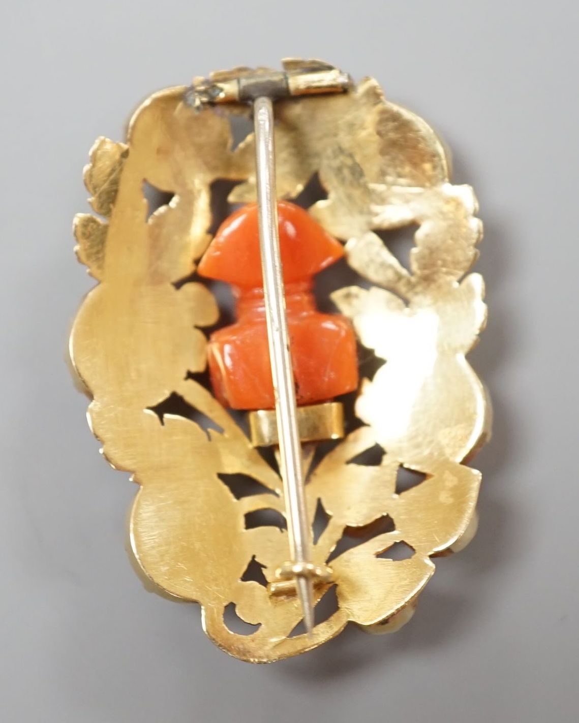 A 19th century yellow metal and coral set foliate brooch, the central motif carved as the bust of Napoleon, 37mm, gross weight 8.7 grams.